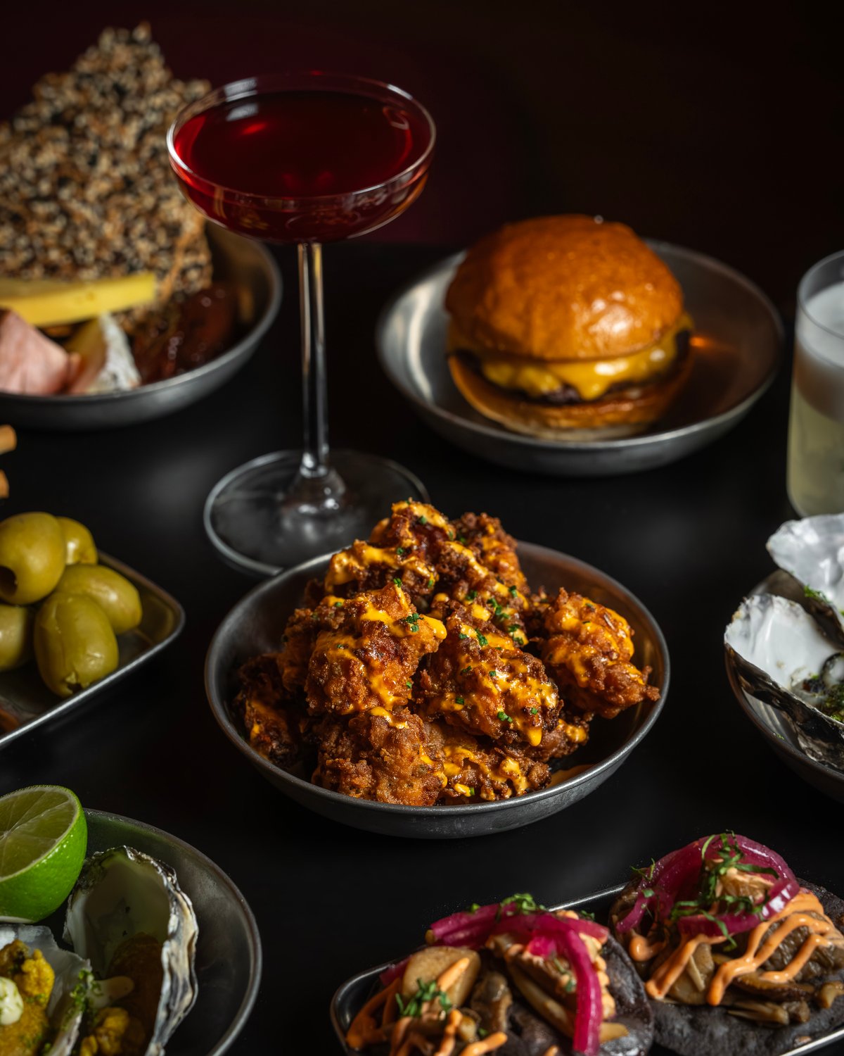 A table filled with food and cocktails at cato